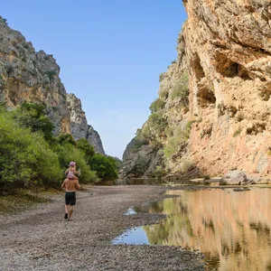 Ein Mann trägt ein kleines Mädchen auf den Schultern, als sie durch die Schlucht Torrent de Pareis auf Mallorca gehen. (Symbolbild)