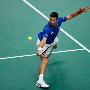 Novak Djokovic im Spagat probiert den Tennisball zu erreichen.