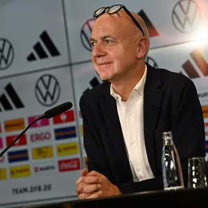 Bernd Neuendorf sitzt vor einem Mikrofon