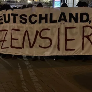 Die Demonstranten mussten auf Anweisung der Polizei ein Transparent abkleben.