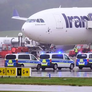 Einsatzfahrzeuge der Polizei stehen vor einem Flugzeug der Iran Air auf dem Flughafen Hamburg.