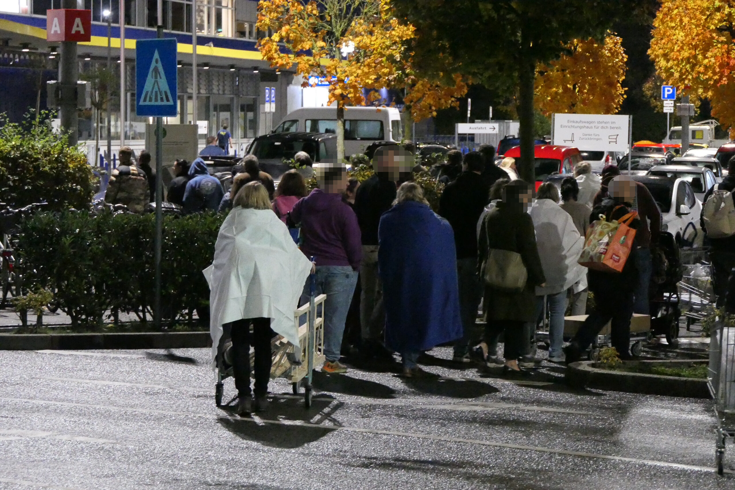 Zahlreiche Menschen haben nach der Evakuierung vor dem „Ikea“ in Kiel gewartet.
