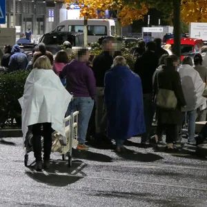 Zahlreiche Menschen haben nach der Evakuierung vor dem „Ikea“ in Kiel gewartet.