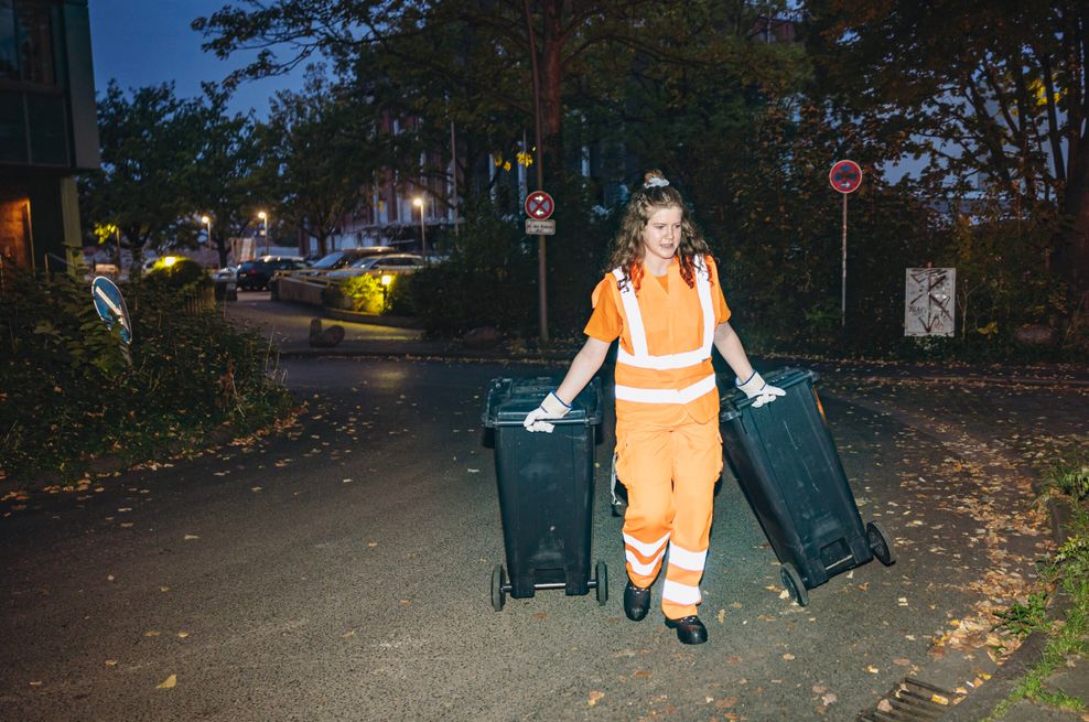 MOPO-Reporterin Pauline Reibe zieht zwei Mülltonnen zum Wagen.