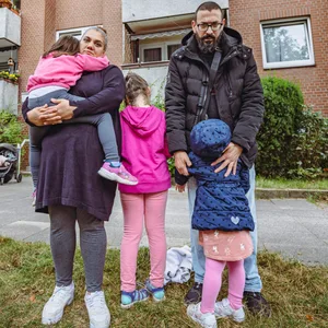 Ali Yapiskan (38) und seine Frau Yasemin (40) mit ihren drei Töchtern vor dem Haus am Erich-Ziegel-Ring (Steilshoop).