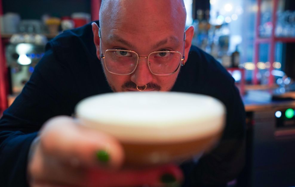 Bar-Chef Frederik Schefferski reicht im „Jing Jing“ einen Cocktail rüber.