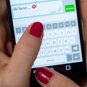 Eine Frau schreibt in einem Messenger eine Nachricht mit dem Inhalt „Hi Sexy ...“. (Symbolbild)