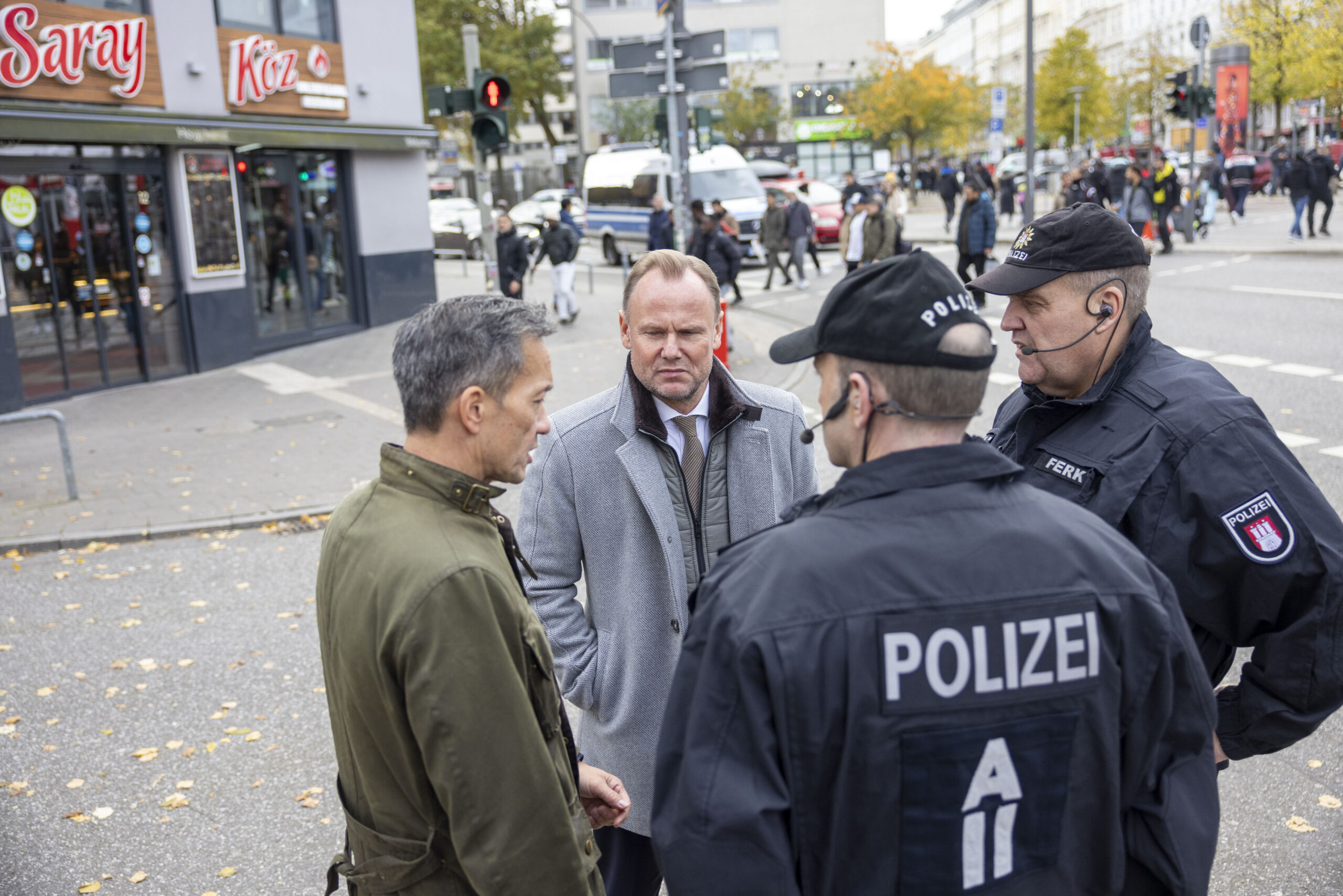 Andy Grote (M.) und Falk Schnabel im Gespräch mit Einsatzleitern der Polizei.