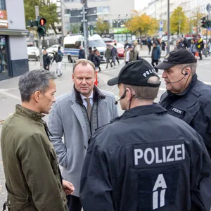 Andy Grote (M.) und Falk Schnabel im Gespräch mit Einsatzleitern der Polizei.