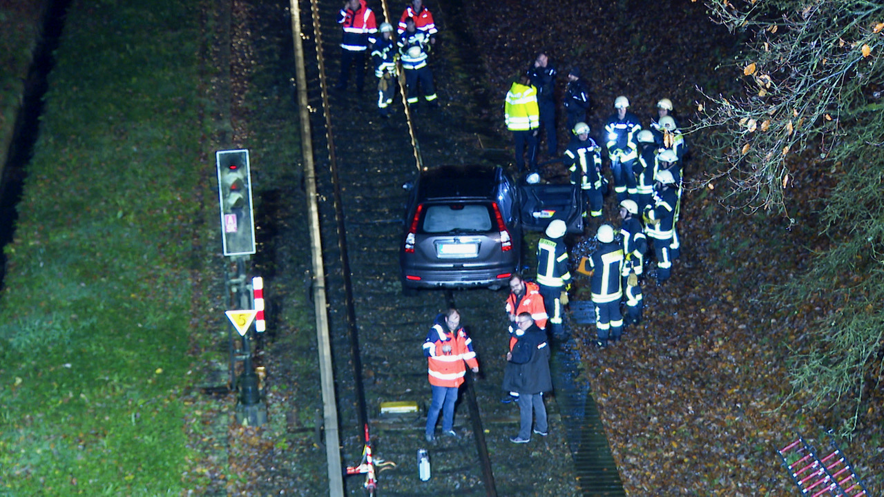 Rettungsleute stehen an dem Auto, mit dem ein 84-Jähriger aus Hamburg am Montagabend bei Ahrensburg auf den Bahngleisen der U1 gefahren ist.