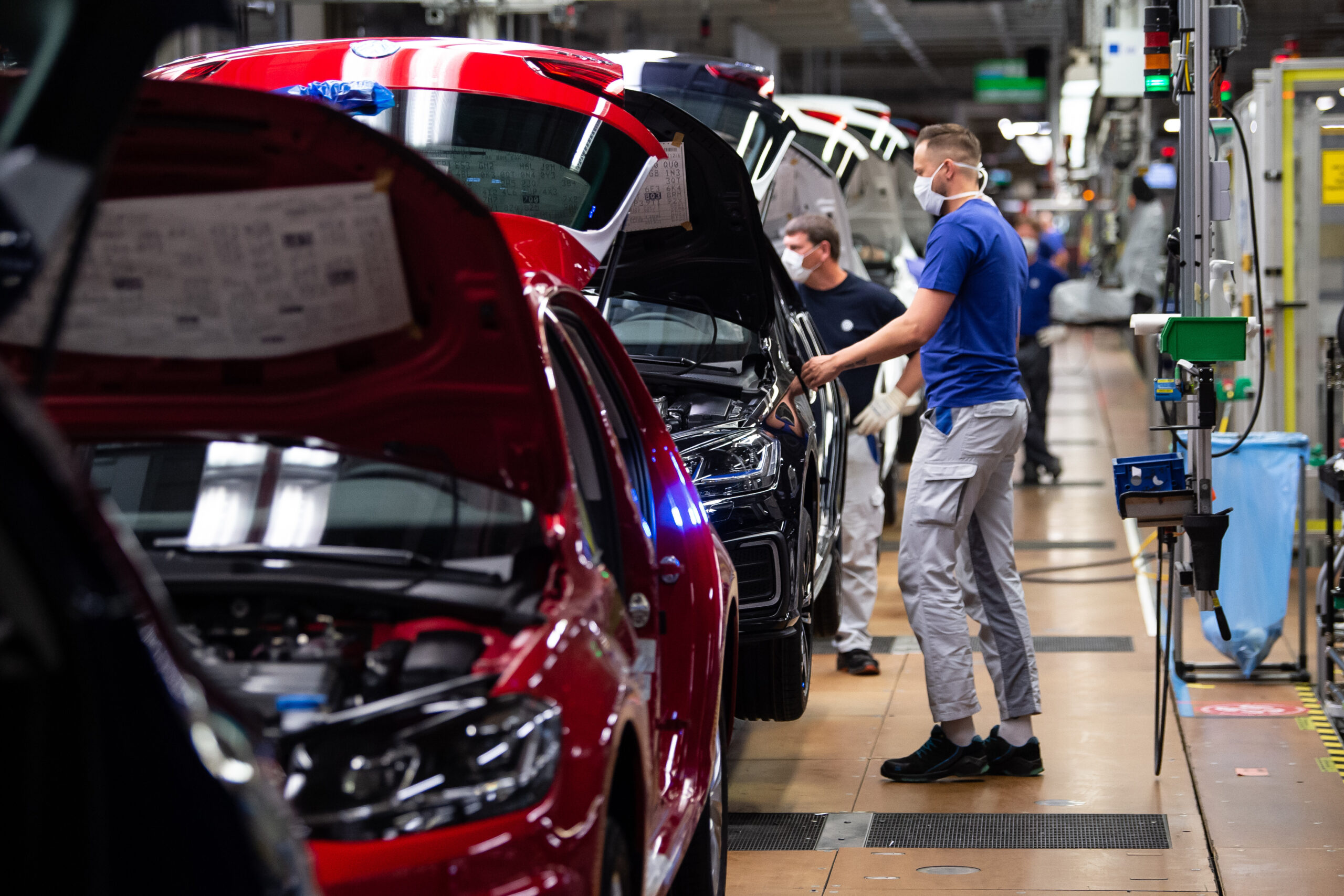 VW-Angestellte arbeiten in der Produktion in Wolfsburg an einem Fahrzeug. (Symbolbild)