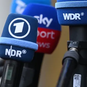 Mikrofone sind während einem Medientermin vor dem Mannschaftshotel der deutschen Handball-Nationalmannschaft zu sehen. (Symbolbild)