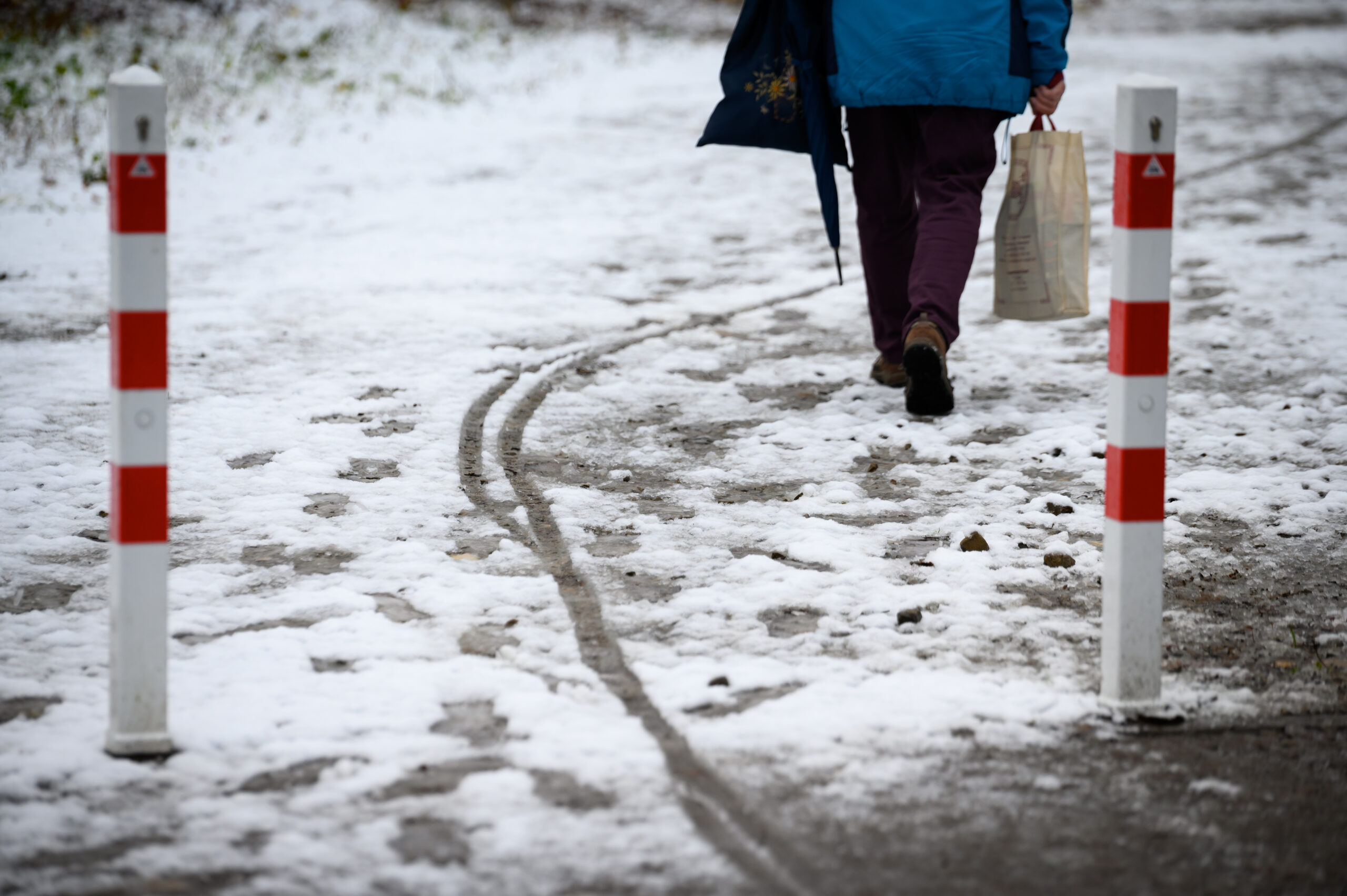 Eine Person läuft einen mit Schneematsch bedeckten Weg entlang. (Symbolbild)