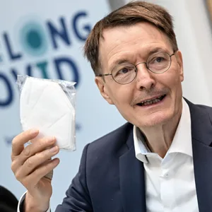 Bundesgesundheitsminister Karl Lauterbach (SPD) hält eine FFP2-Maske.
