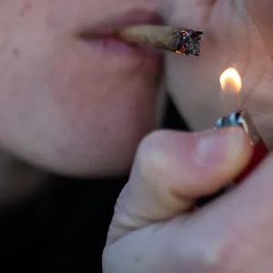 Cannabis-Konsum: Eine junge Frau raucht einen Joint (Symbolfoto).
