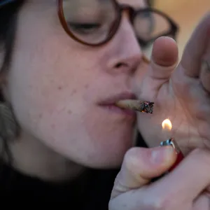 Eine junge Frau raucht einen Cannabis-Joint (Symbolfoto).