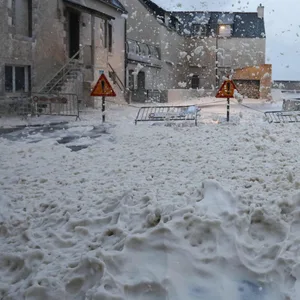 Schaum und Gischt fließen über eine Straße in Penmarc'h in Westfrankreich.