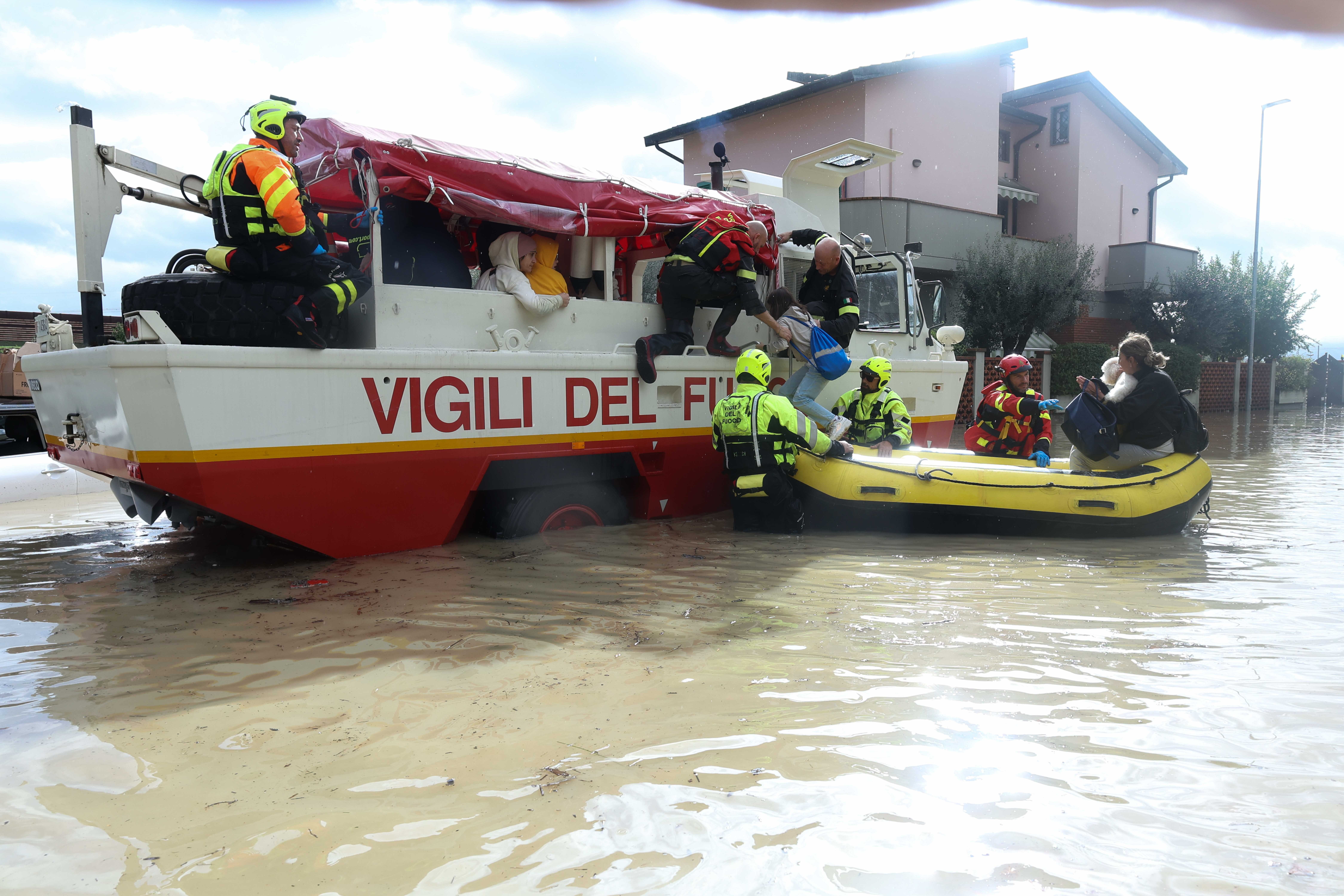 Helfer bringen Opfer der Überschwemmung in einem Schlauchboot in Sicherheit.