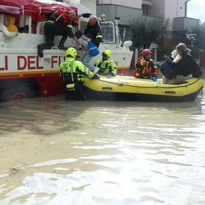 Helfer bringen Opfer der Überschwemmung in einem Schlauchboot in Sicherheit.