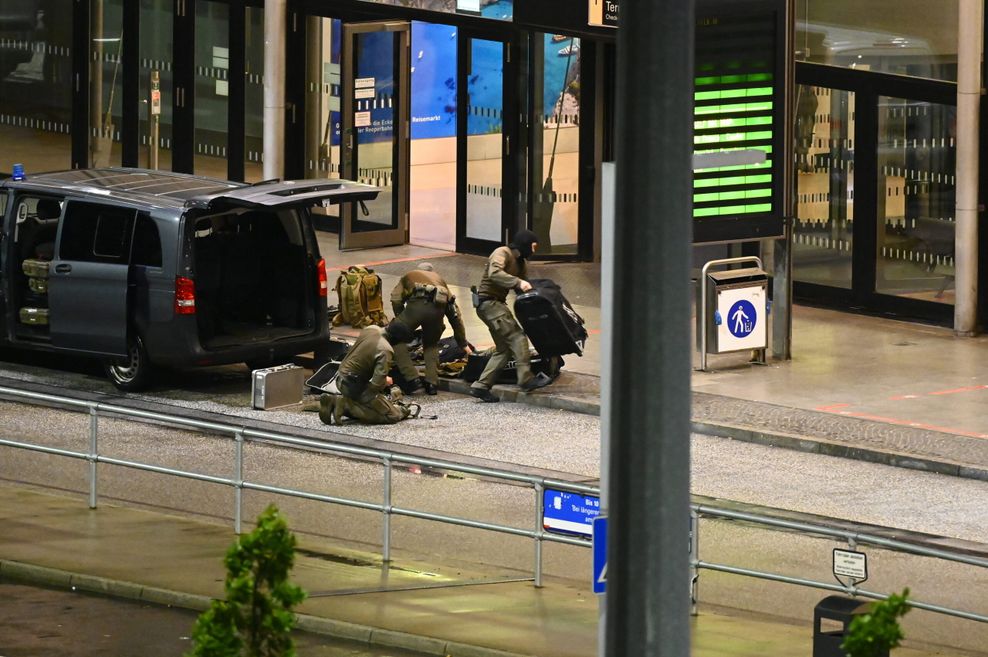 Bewaffnete Polizisten bereiten sich mit Spezialausrüstung auf den Einsatz am Flughafen vor.