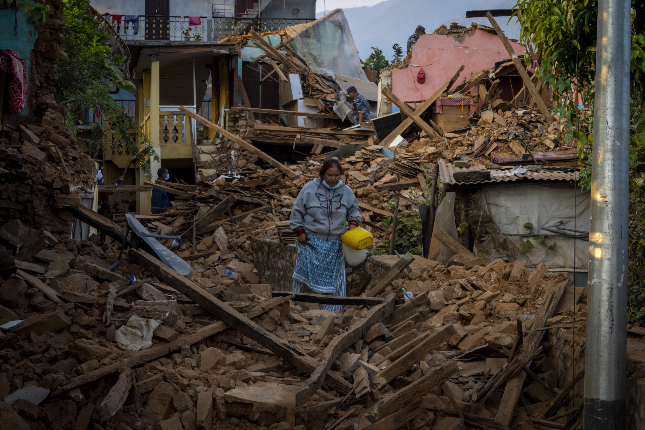 Eine Frau geht an eingestürzten Häusern im Nordwesten Nepals vorbei.
