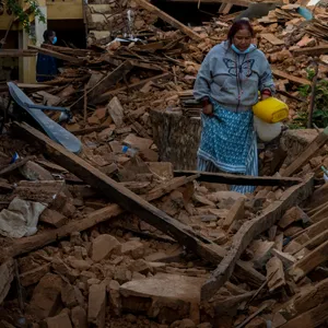 Eine Frau geht an eingestürzten Häusern im Nordwesten Nepals vorbei.