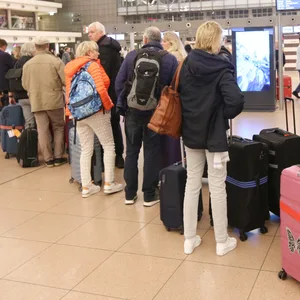 Reisende stehen im Terminal 1 am Hamburger Flughafen in einer Schlange.