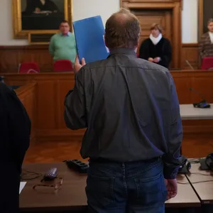 Der Angeklagte steht zu Beginn des Prozesses wegen Besitzes kinderpornographischer Inhalte im Sitzungssaal im Ziviljustizgebäude.