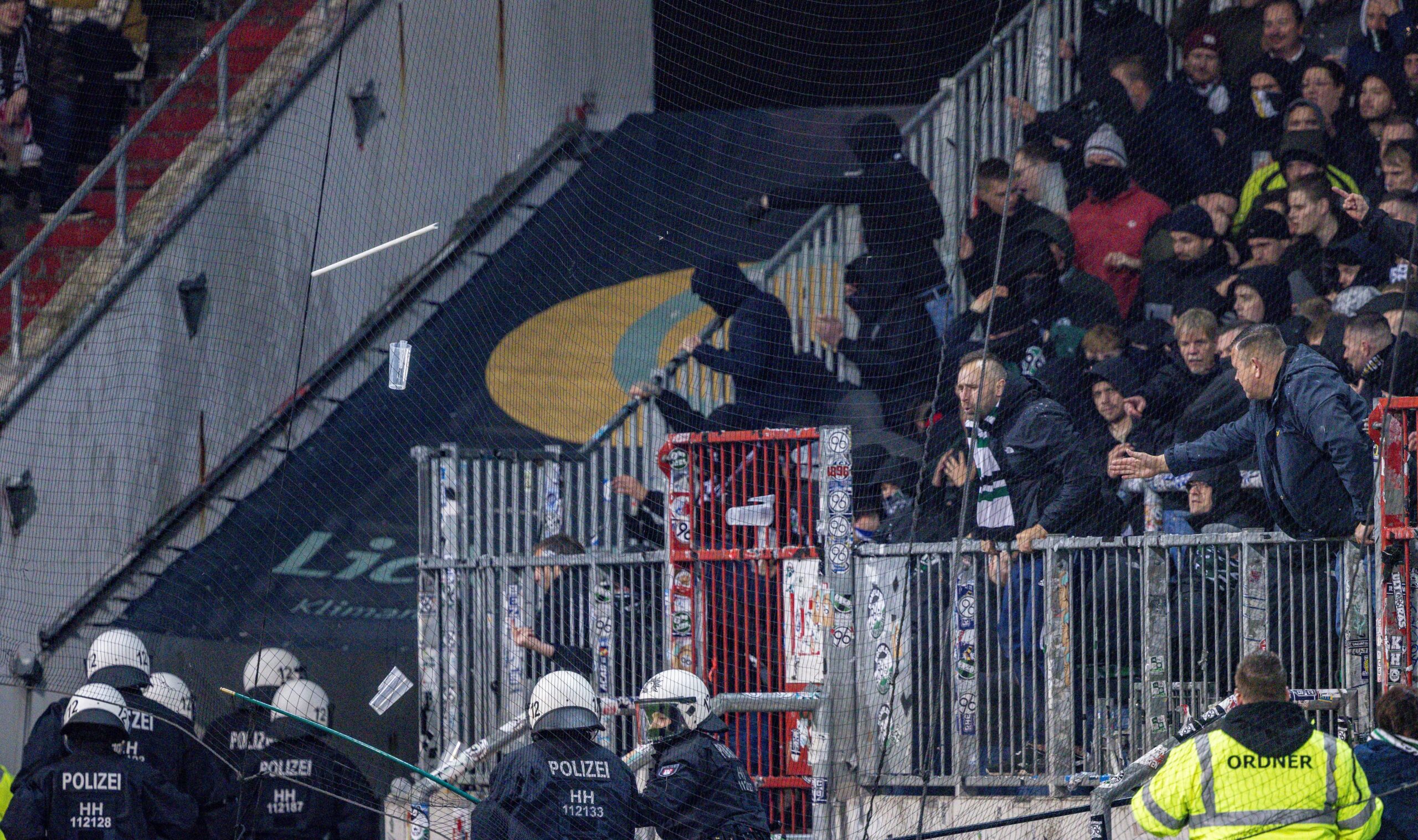 FC St. Pauli gegen Hannover 96: Gegenstände werden aus dem Fanblock der Hannoveraner auf Einsatzkräfte der Polizei geworfen.