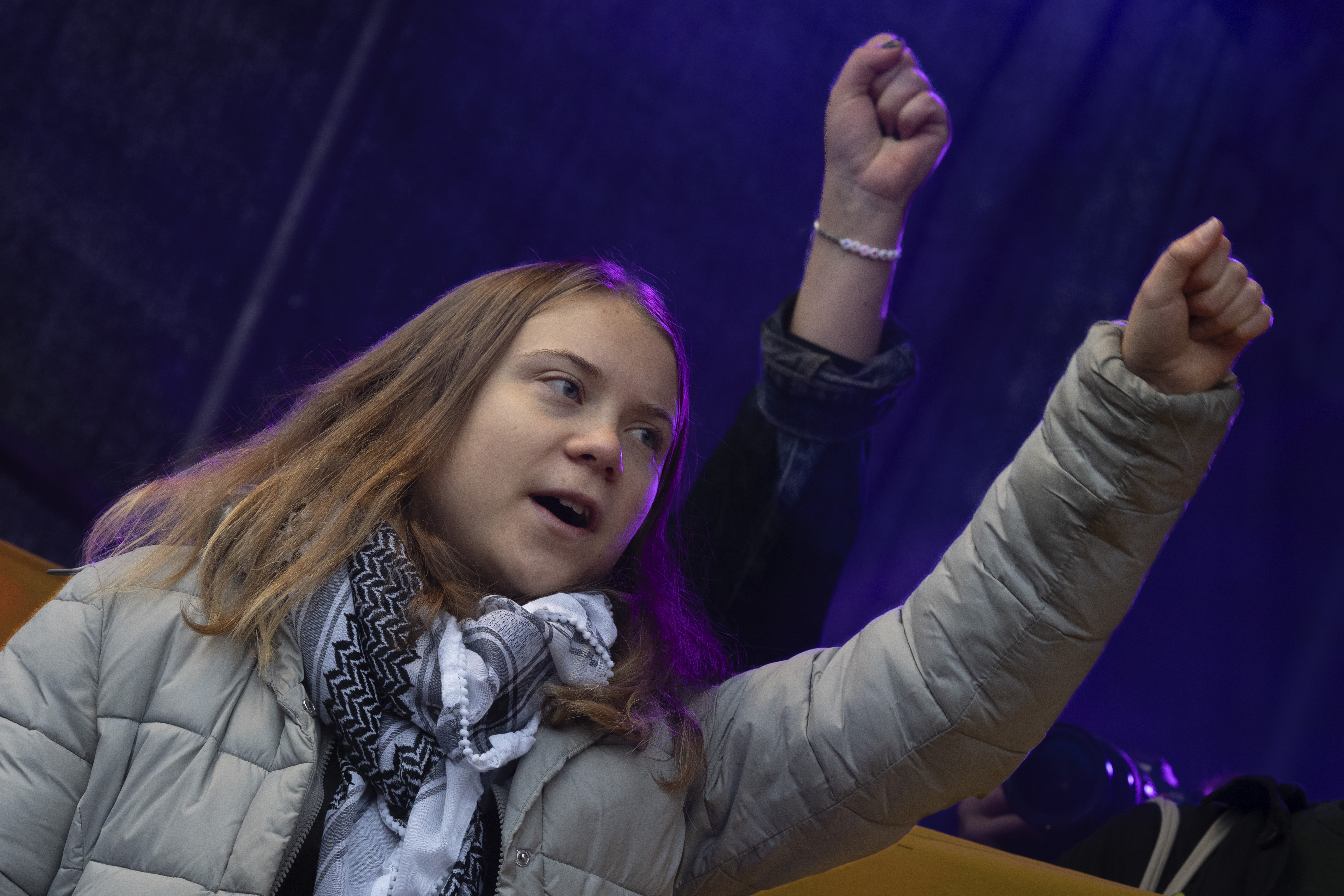 Greta Thunberg mit erhobener Faust, sie ruft etwas.