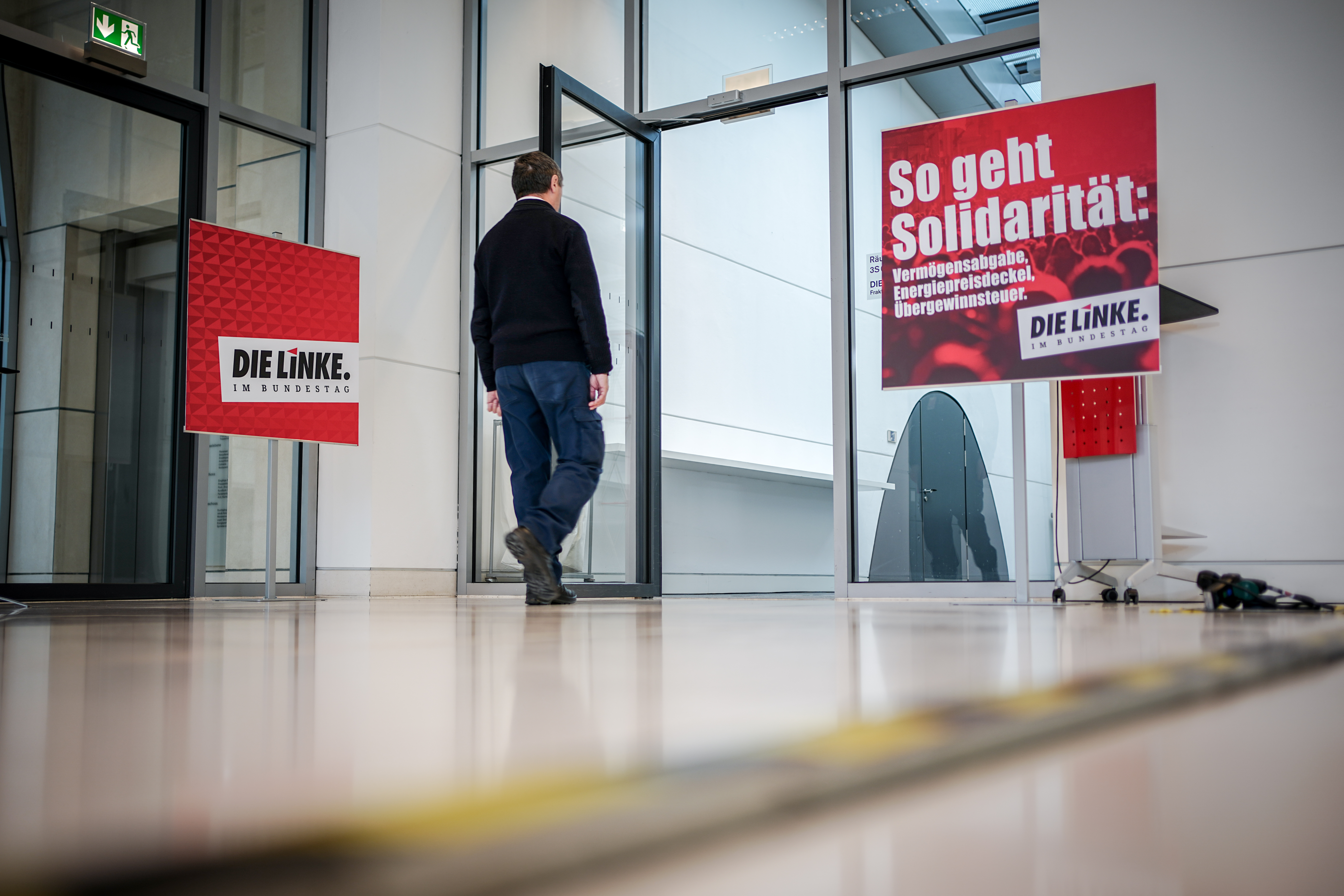 Ein Mitarbeiter des Bundestags geht zum Sitzungssaal der Fraktion von Die Linke auf der Fraktionsebene im Bundestag neben einem Plakat mit der Aufschrift «So geht Solidarität:» .