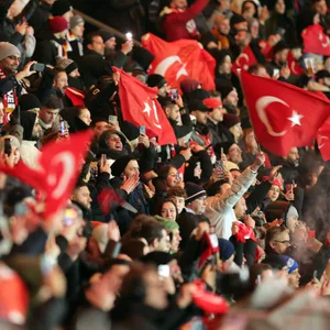 Fans im Stadion halten türkische Fahnen in die Luft