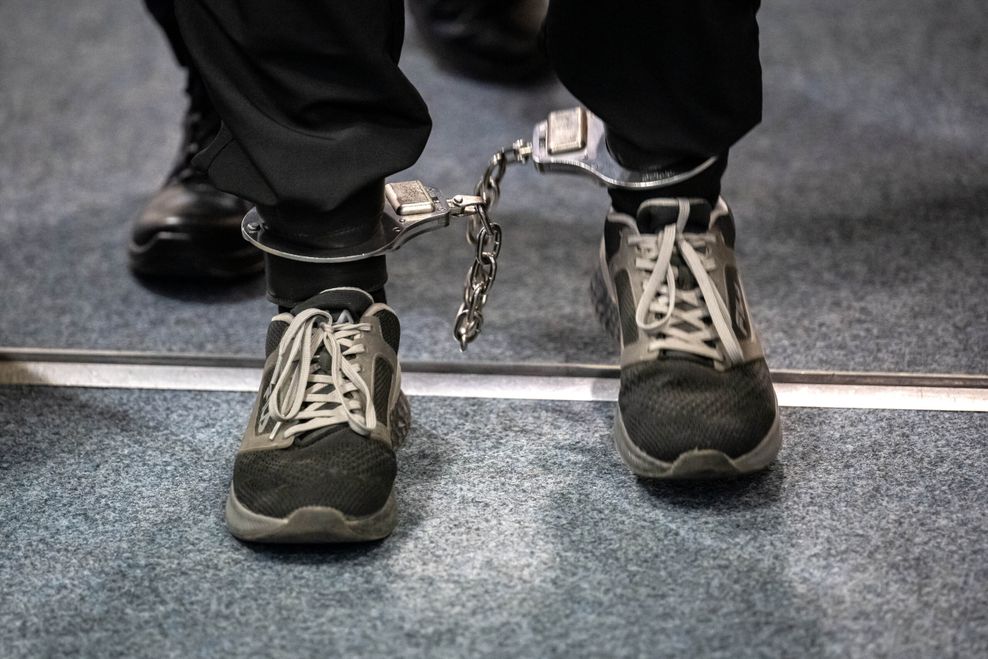 Der Angeklagte wird mit Fußfesseln in den Gerichtssaal geführt.