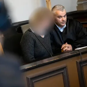 Die Angeklagte sitzt vor Prozessbeginn mit ihrem Anwalt im Gerichtssaal.