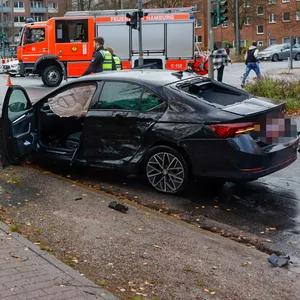 Drei nach einem Unfall beschädigte Autos stehen an der Kreuzung Krausestraße/Straßburger Straße in Hamburg. Feuerwehr, Polizei und Rettungsleute begutachten die Unfallstelle.