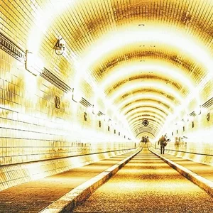 Ein Mann geht durch den erleuchteten Alten Elbtunnel