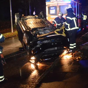 Rettungskräfte sichern das Fahrzeug, um es wieder aufzurichten.
