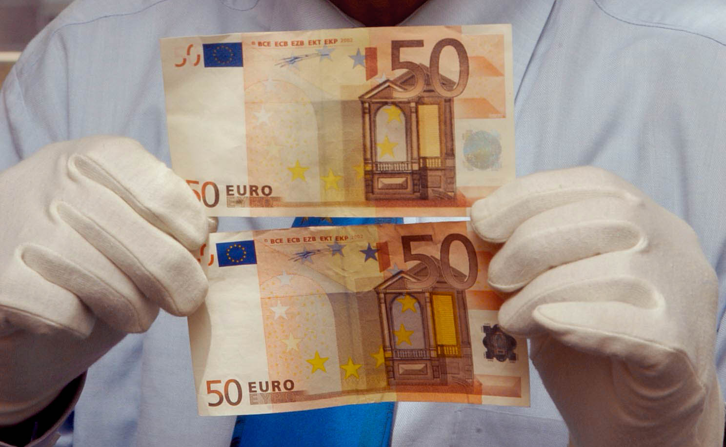 „Falsche Fuffziger“: Ein Kripobeamter zeigt zwei gefälschte 50-Euro-Banknoten.