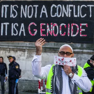 Pro-Palästina-Protest: Ein Mann hält ein Plakat hoch, auf dem steht: „It ist not a conflict, it is a genocide“.