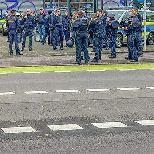 Polizisten stehen vor der Schule in Offenburg, an der ein 15-Jähriger einem Mitschüler in den Hinterkopf geschossen hat.