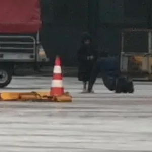 Das entführte Mädchen (4) neben seinem Vater, der sich der Polizei ergeben hat und auf dem Rollfeld liegt.