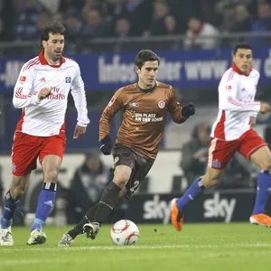 Fin Bartels mit Ball am Fuß, gejagt von Ruud van Nistelrooy