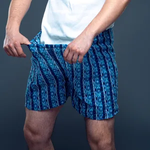 Ein Mann zieht den Bund seiner Unterhose von sich weg und sieht hinunter.