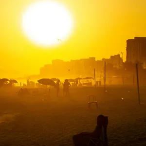 Ein Strand in Rio de Janeiro mit der untergehenden Sonne im Hintergrund
