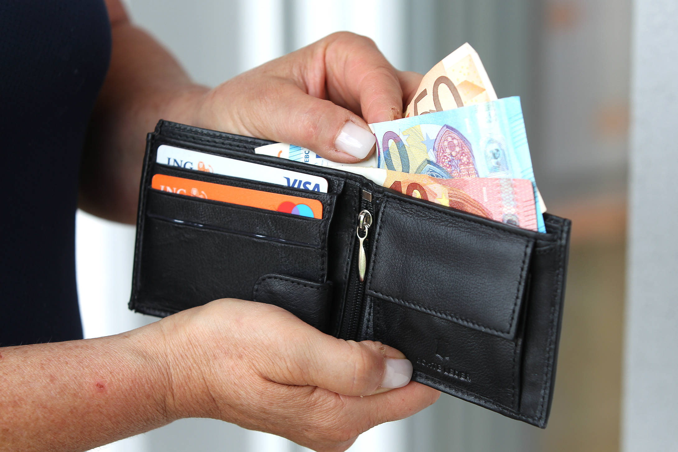 Frau nimmt Geld aus ihrem Portemonnaie