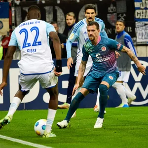 Simon Zoller will einen Pass von Schalkes Ibrahima Cisse (l.) abfangen.