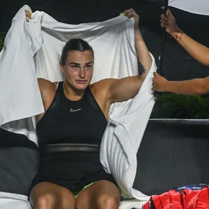 Aryna Sabalenka (l.) muss mit einem Schirm vor dem Starkregen in Cancun geschützt werden.