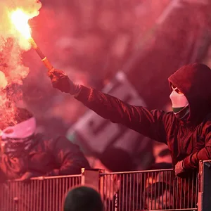 Ein maskierter Fan zündet während der Partie zwischen Hannover und Braunschweig Pyrotechnik
