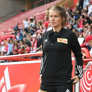 Marie-Louise Eta im Union Berlin Hoodie an der Seitenlinie.