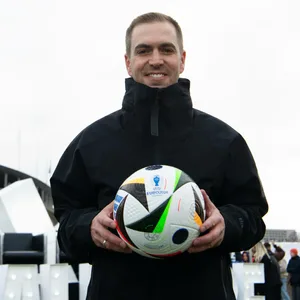 Philipp Lahm hält den Ball in die Kamera.